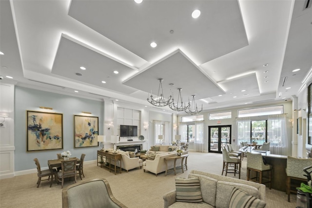 carpeted living room with a notable chandelier, a tray ceiling, and french doors