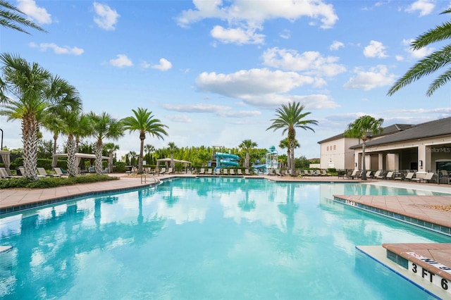 view of pool featuring a water slide and a patio