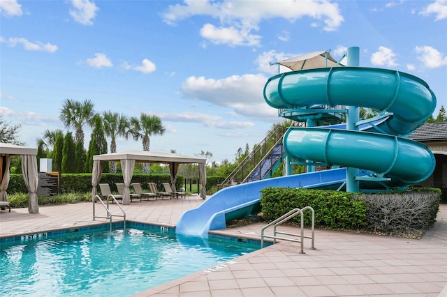 view of swimming pool featuring a gazebo, a water slide, a playground, and a patio area