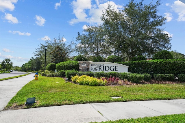 community / neighborhood sign featuring a lawn