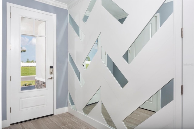 foyer entrance with light hardwood / wood-style flooring and ornamental molding