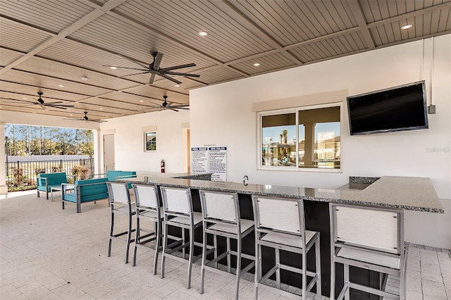 view of patio / terrace featuring ceiling fan and exterior bar