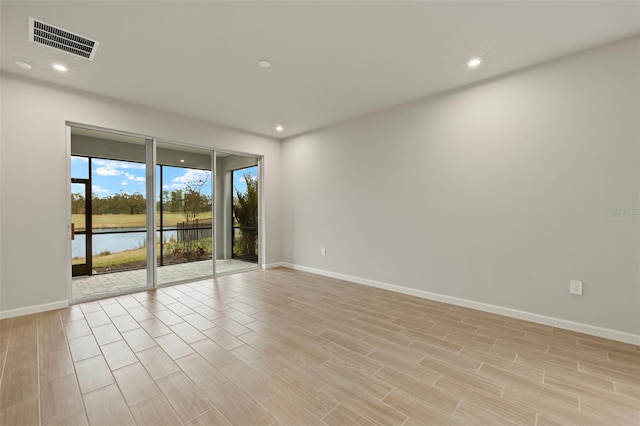 unfurnished room featuring a water view