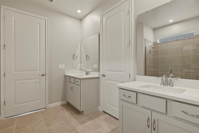 bathroom featuring a tile shower and vanity