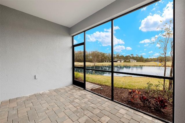 unfurnished sunroom featuring a water view