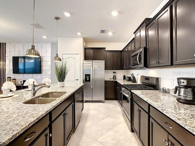 7472 Oakmoss Loop, Davenport, FL 33837 - kitchen with stainless steel appliances, a sink, light stone countertops, light tile patterned floors, and tasteful backsplash