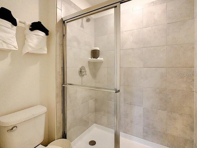 bathroom with toilet and an enclosed shower