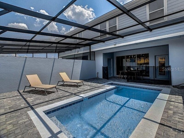 view of swimming pool featuring a patio area and glass enclosure