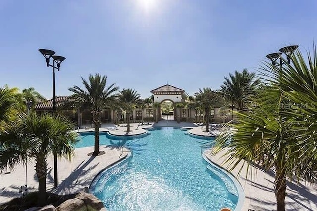 7472 Oakmoss Loop, Davenport, FL 33837 - community pool featuring a patio area