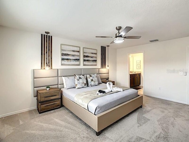 7472 Oakmoss Loop, Davenport, FL 33837 - bedroom featuring light carpet, baseboards, ensuite bathroom, and a ceiling fan