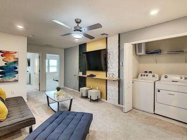 carpeted living room with ceiling fan and washer and dryer