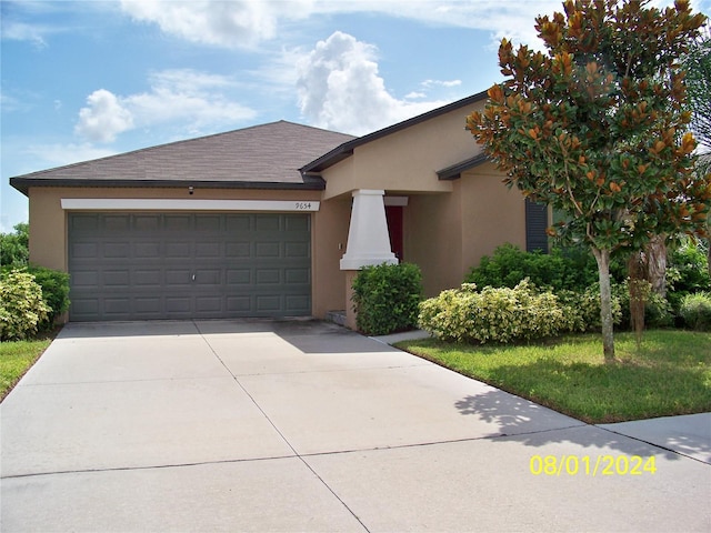 view of front facade featuring a front yard and a garage