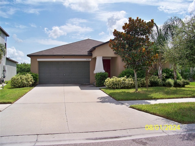 view of front of home with a front yard and a garage