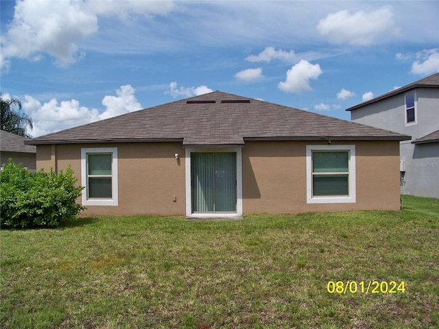 rear view of property with a yard