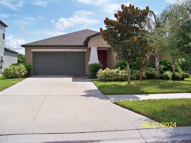 view of front of house with a front yard and a garage