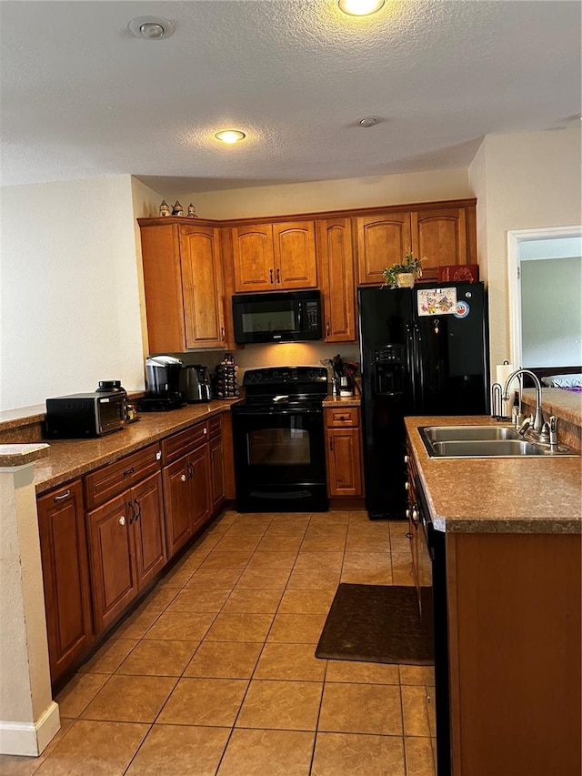 kitchen featuring light tile patterned floors, a textured ceiling, sink, and black appliances