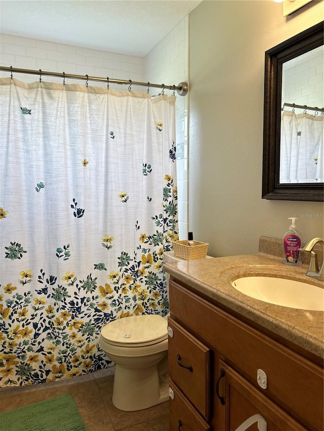 bathroom featuring tile patterned flooring, curtained shower, vanity, and toilet