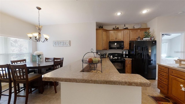 kitchen with light tile patterned flooring, ceiling fan with notable chandelier, hanging light fixtures, and black appliances