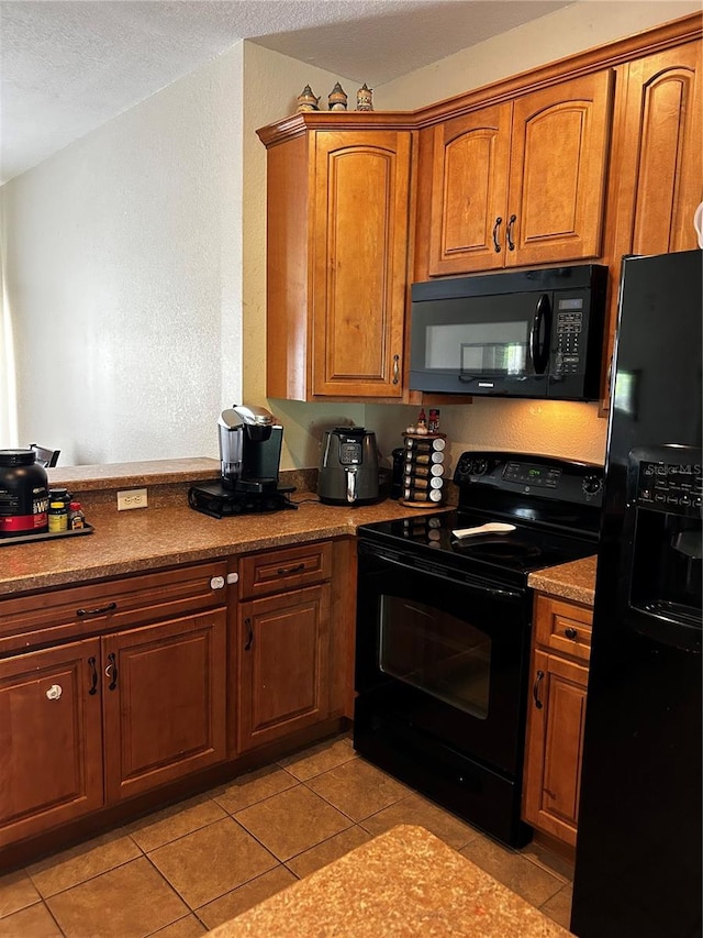 kitchen featuring light tile patterned floors and black appliances