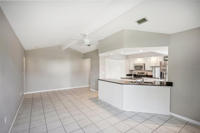 kitchen with lofted ceiling with beams, stainless steel appliances, light tile patterned flooring, white cabinetry, and ceiling fan