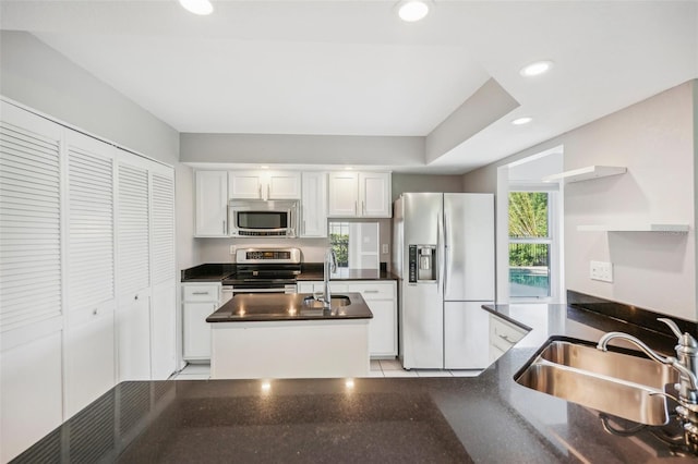 kitchen with light tile patterned flooring, sink, appliances with stainless steel finishes, and white cabinets