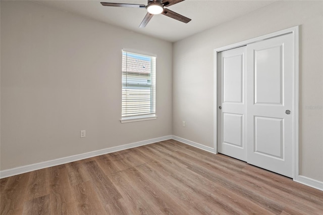 unfurnished bedroom with ceiling fan, light hardwood / wood-style flooring, and a closet