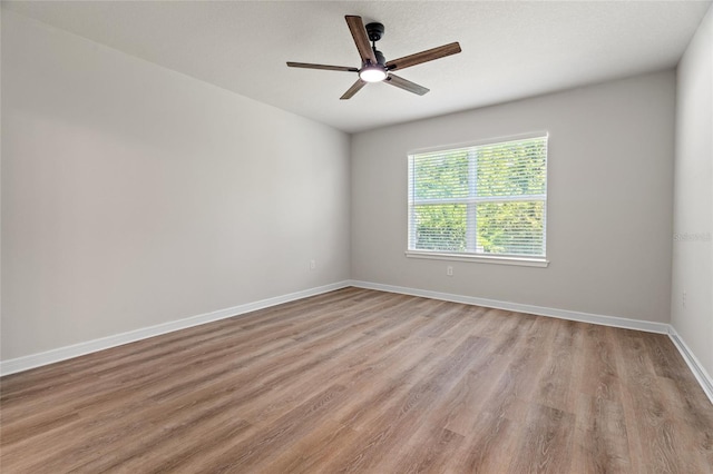 spare room featuring wood-type flooring and ceiling fan