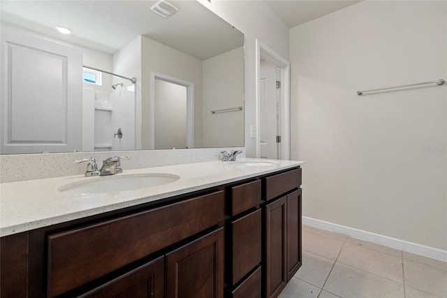 bathroom with double sink vanity and tile patterned flooring