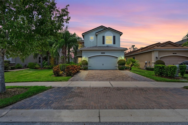 view of front of home with a garage and a lawn