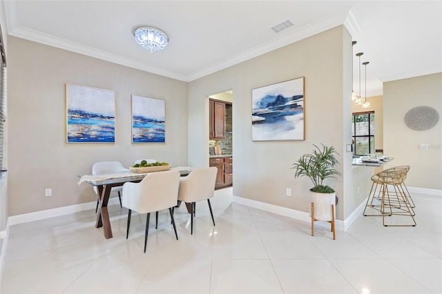 dining area featuring an inviting chandelier, light tile patterned floors, and ornamental molding