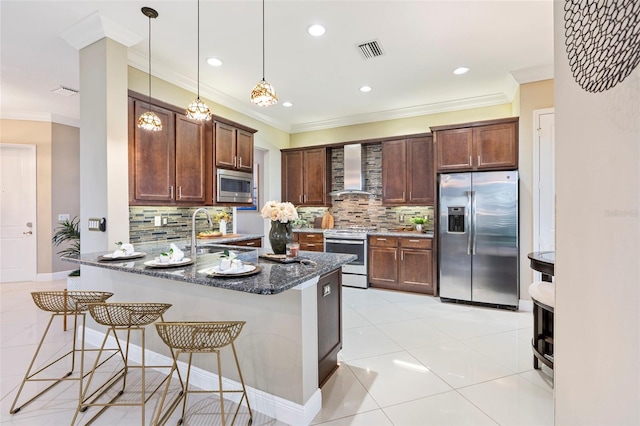 kitchen with sink, a breakfast bar, appliances with stainless steel finishes, kitchen peninsula, and wall chimney exhaust hood