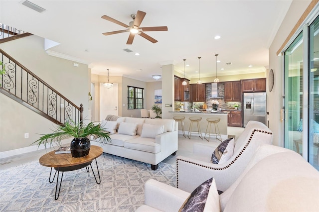 living room featuring crown molding and ceiling fan