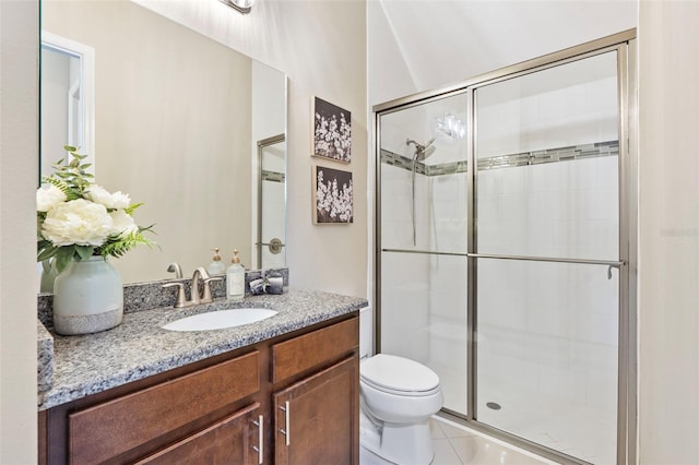 bathroom featuring walk in shower, vanity, tile patterned floors, and toilet