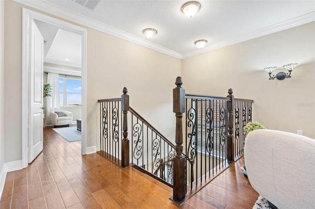 staircase with hardwood / wood-style flooring and crown molding