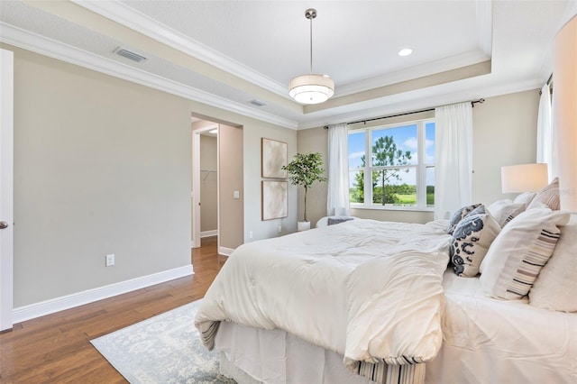 bedroom featuring a raised ceiling, crown molding, and dark wood-type flooring