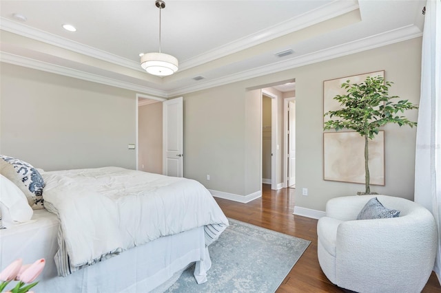 bedroom featuring a raised ceiling, ornamental molding, and dark wood-type flooring