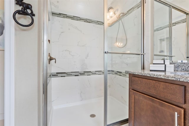 bathroom featuring vanity and a shower with door