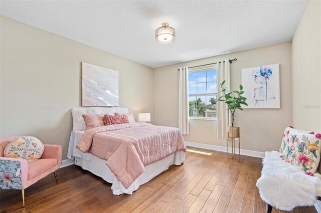 bedroom featuring hardwood / wood-style floors and a textured ceiling