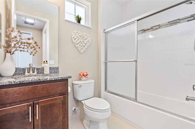 full bathroom with vanity, bath / shower combo with glass door, and toilet