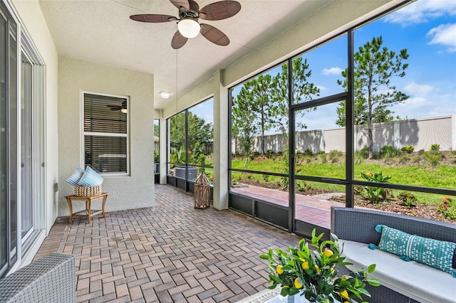 unfurnished sunroom featuring ceiling fan