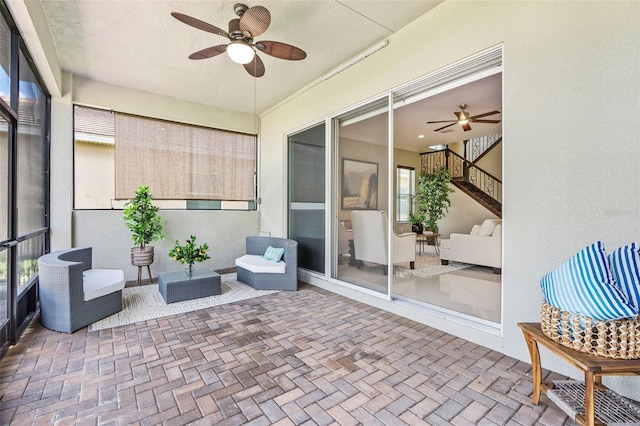 sunroom / solarium featuring ceiling fan