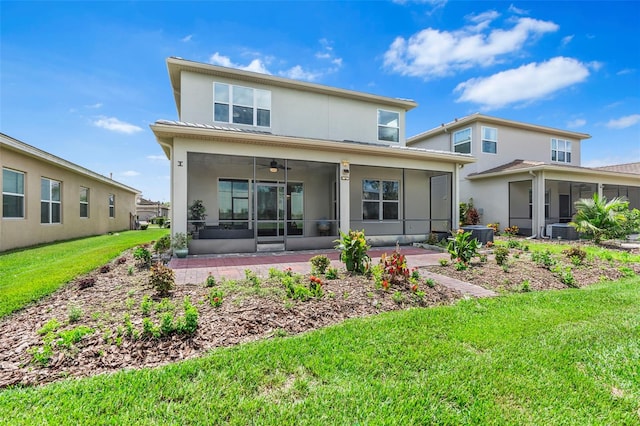 rear view of property with a sunroom, a yard, central AC unit, and ceiling fan