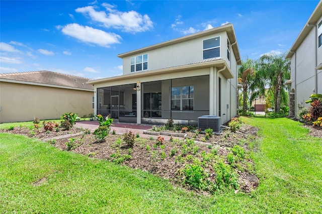 back of property with central AC unit, a lawn, and a sunroom