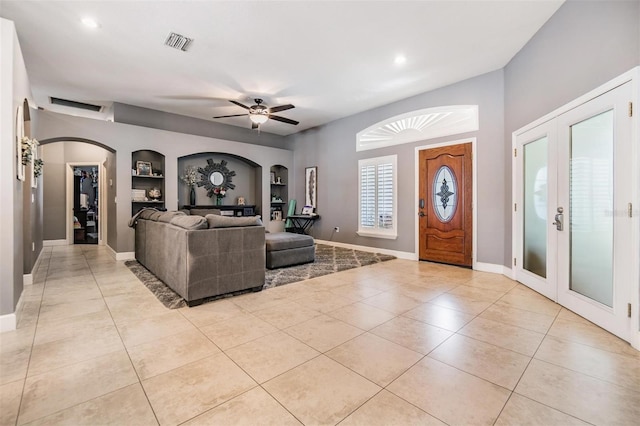 living room featuring french doors, built in features, light tile patterned floors, and ceiling fan