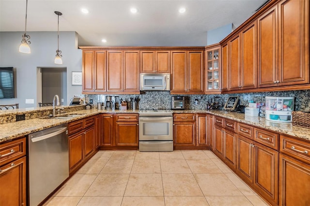 kitchen featuring light tile patterned flooring, stainless steel dishwasher, stove, and light stone counters