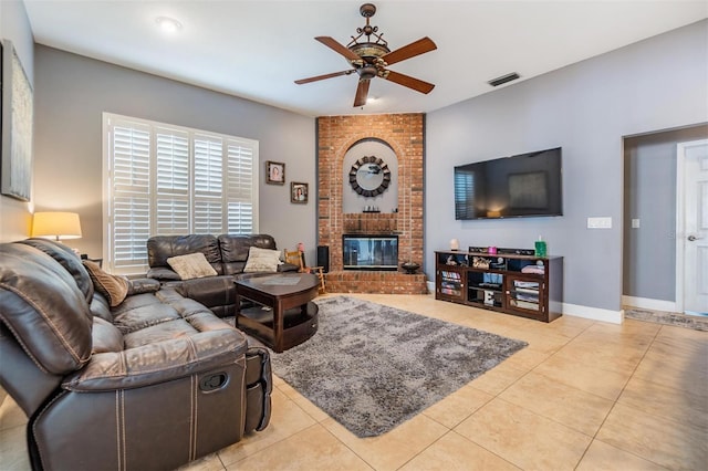 tiled living room featuring a brick fireplace, brick wall, and ceiling fan