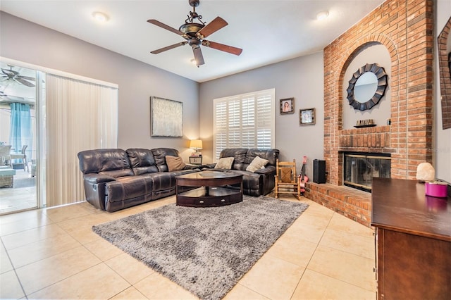 living room featuring light tile patterned floors, a brick fireplace, and ceiling fan