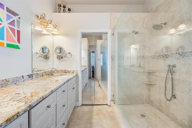 bathroom with tile patterned floors, vanity, and a tile shower