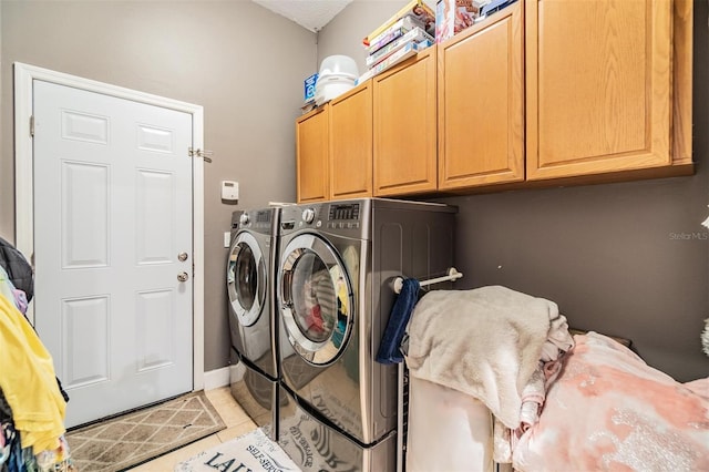 laundry area featuring light tile patterned floors, independent washer and dryer, and cabinets