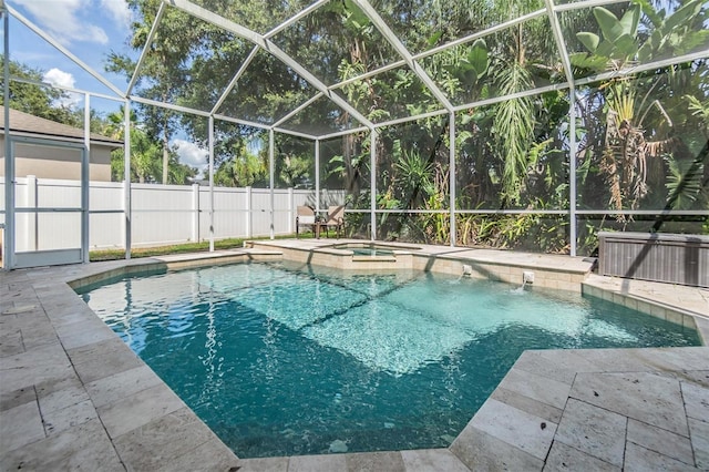 view of swimming pool with an outdoor hot tub and glass enclosure